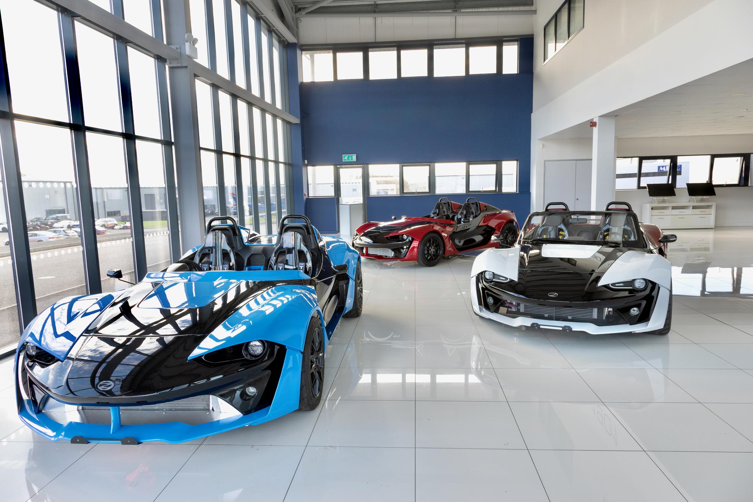 Blue Zenos E10 in the showroom with two more E10s behind
