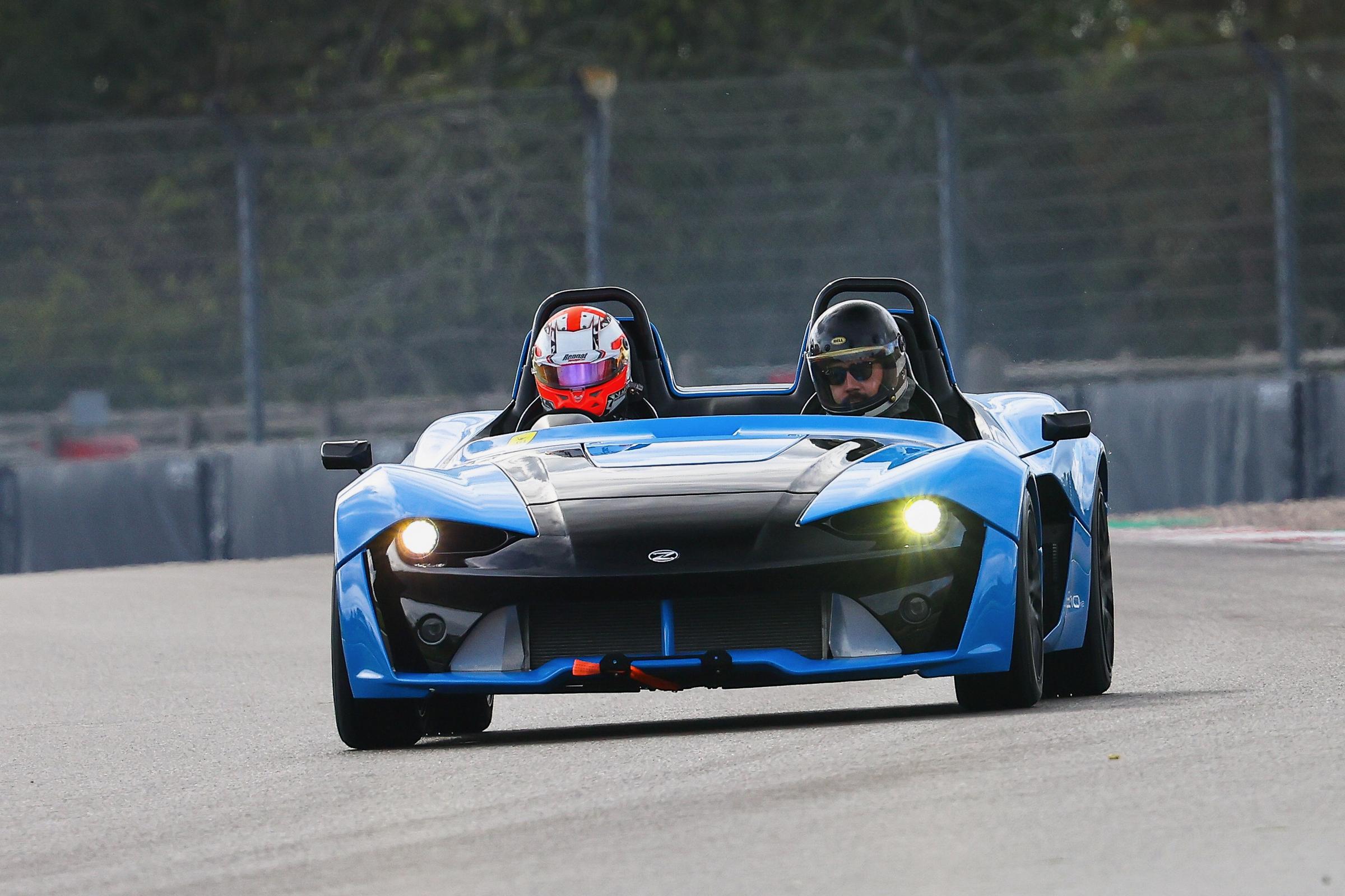 Zenos E10 head on at speed, headlights on